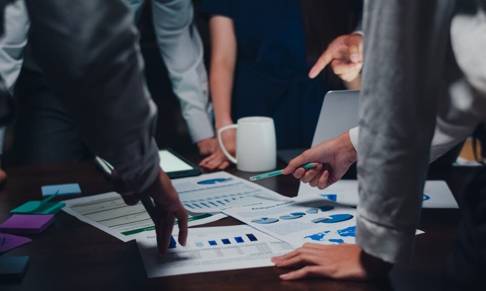 millennial asia businessmen businesswomen meeting brainstorming ideas about new paperwork project colleagues working together planning success strategy enjoy teamwork small modern night office 1024x576